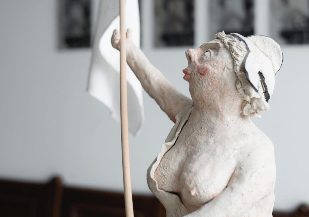 Kunstwerk Skulptur in unserer Kanzlei halbnackte Frau mit Fahne
